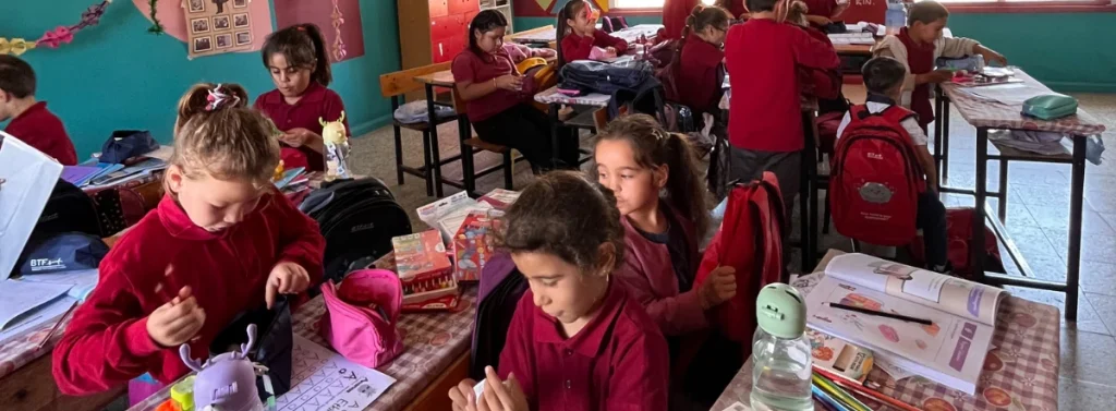 Students at Haydarlar Elementary School in Hatay, Türkiye, explore their new BTF backpacks and school supplies while seated at their classroom desks.