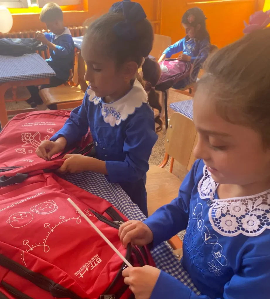 Students at Osmangazi Elementary School in Ağrı, Türkiye, unpack their new BTF backpacks together in a classroom.