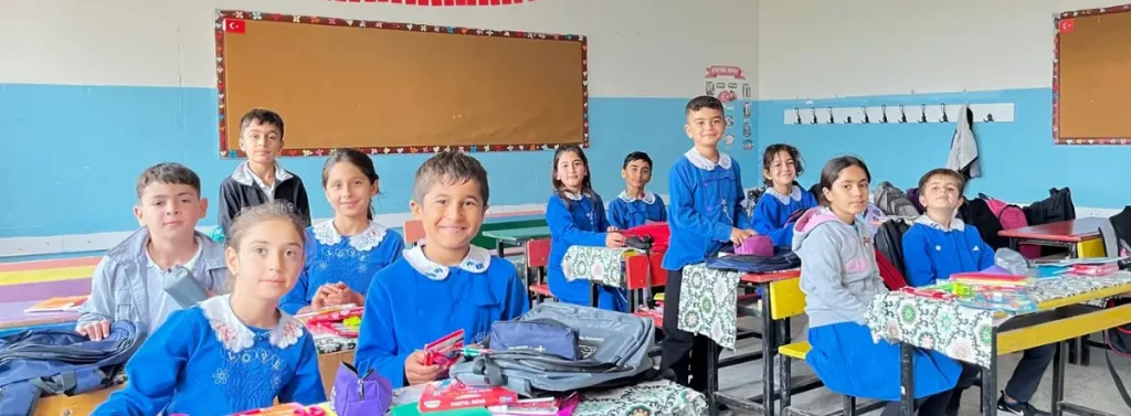 Students at Azıklı Elementary School in Şanlıurfa, Türkiye, smile in their classroom with new backpacks and school supplies provided through BTF's Back to School Campaign.