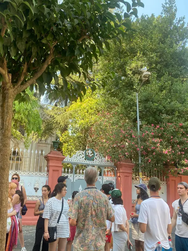 Participants of the 2025 Nâzım Hikmet Summer Camp gather outdoors near a historic gated entrance in Büyükada, Istanbul.